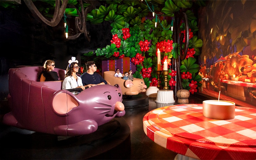 Guests enjoying Ratatouille ride at Walt Disney World Resort, Orlando, surrounded by vibrant decor.