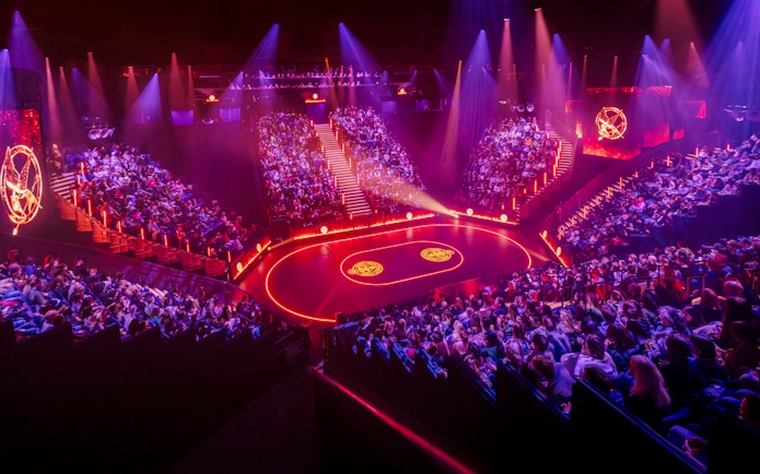 Hunger Games West End show stage with audience in a circular theater setting.