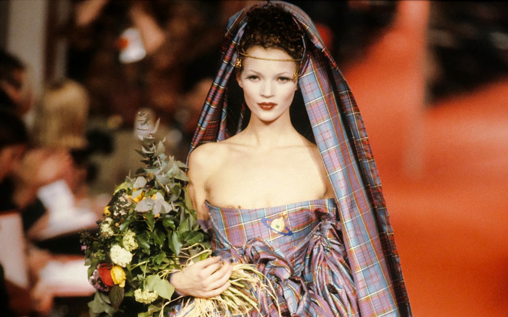 Model in tartan dress holding flowers at Westwood | Kawakubo Exhibition, NGV.