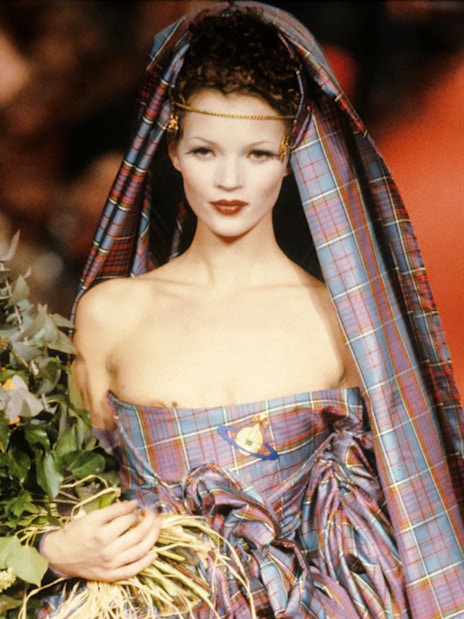 Model in tartan dress holding flowers at Westwood | Kawakubo Exhibition, NGV.