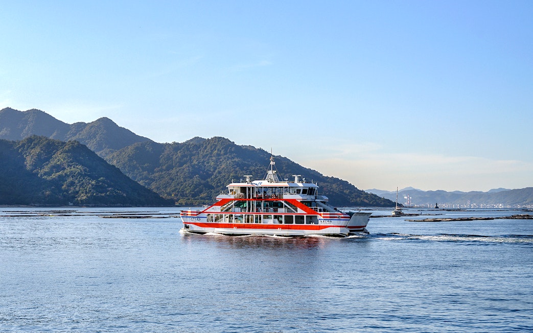 Ferry crossing Seto Inland Sea with mountains in the background, Japan.