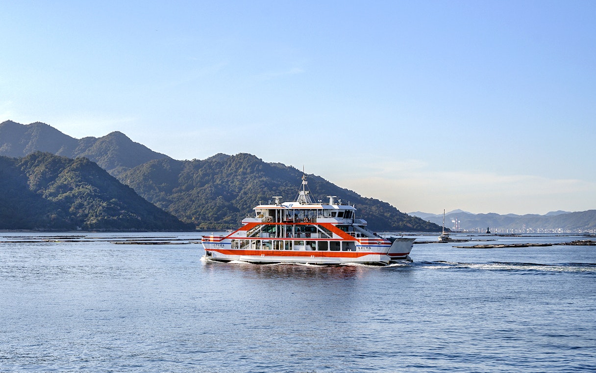Ferry crossing Seto Inland Sea with mountains in the background, Japan.