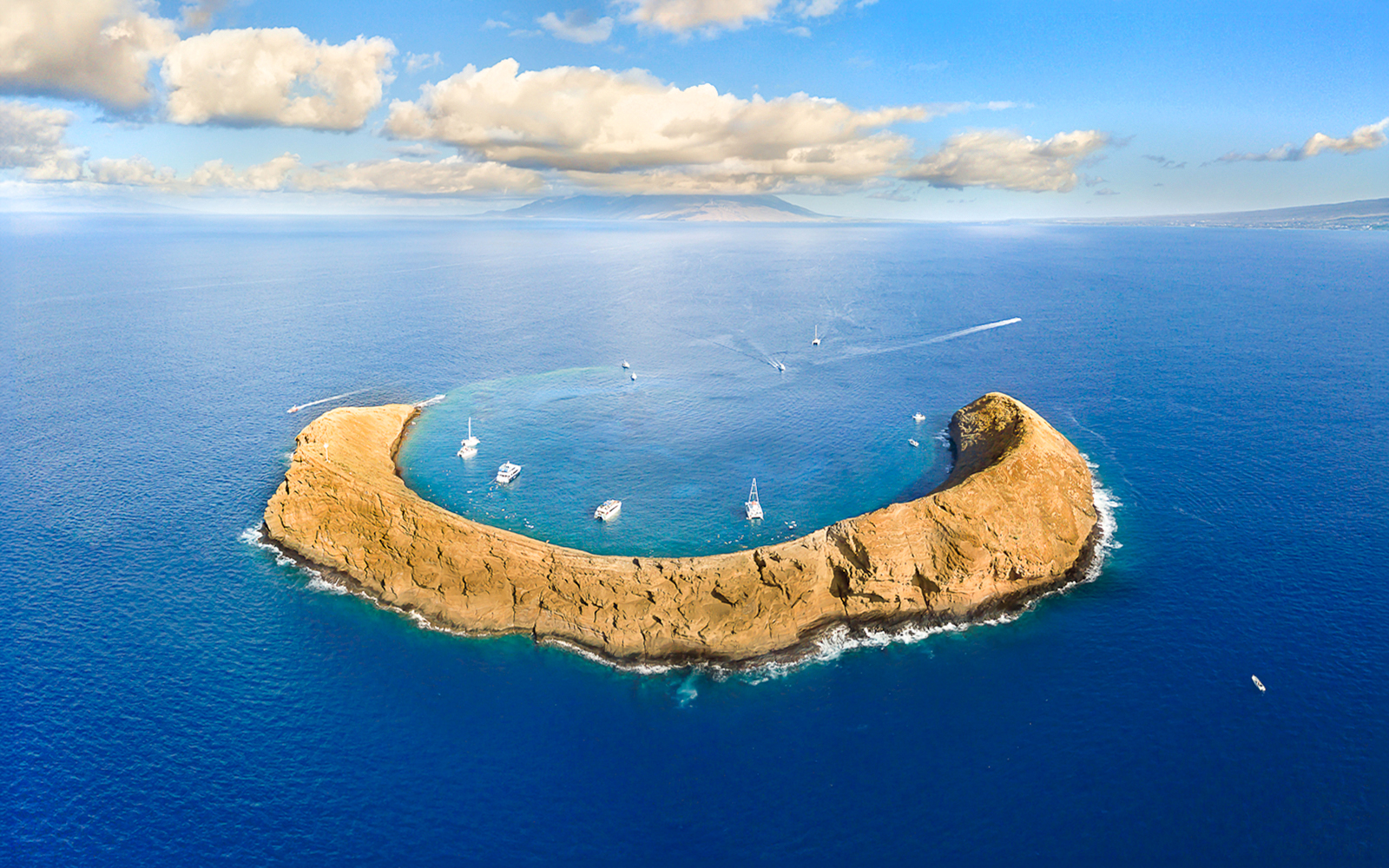 Molokini Crater with boats in clear waters, Maui, Hawaii.