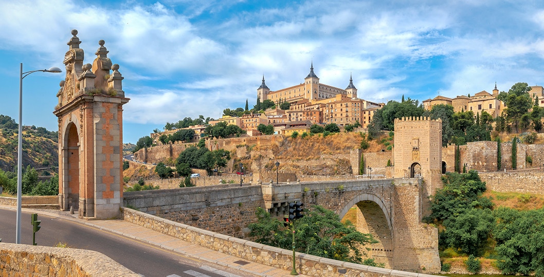 Alcazar and San Martin Bridge in Toledo with scenic river view.