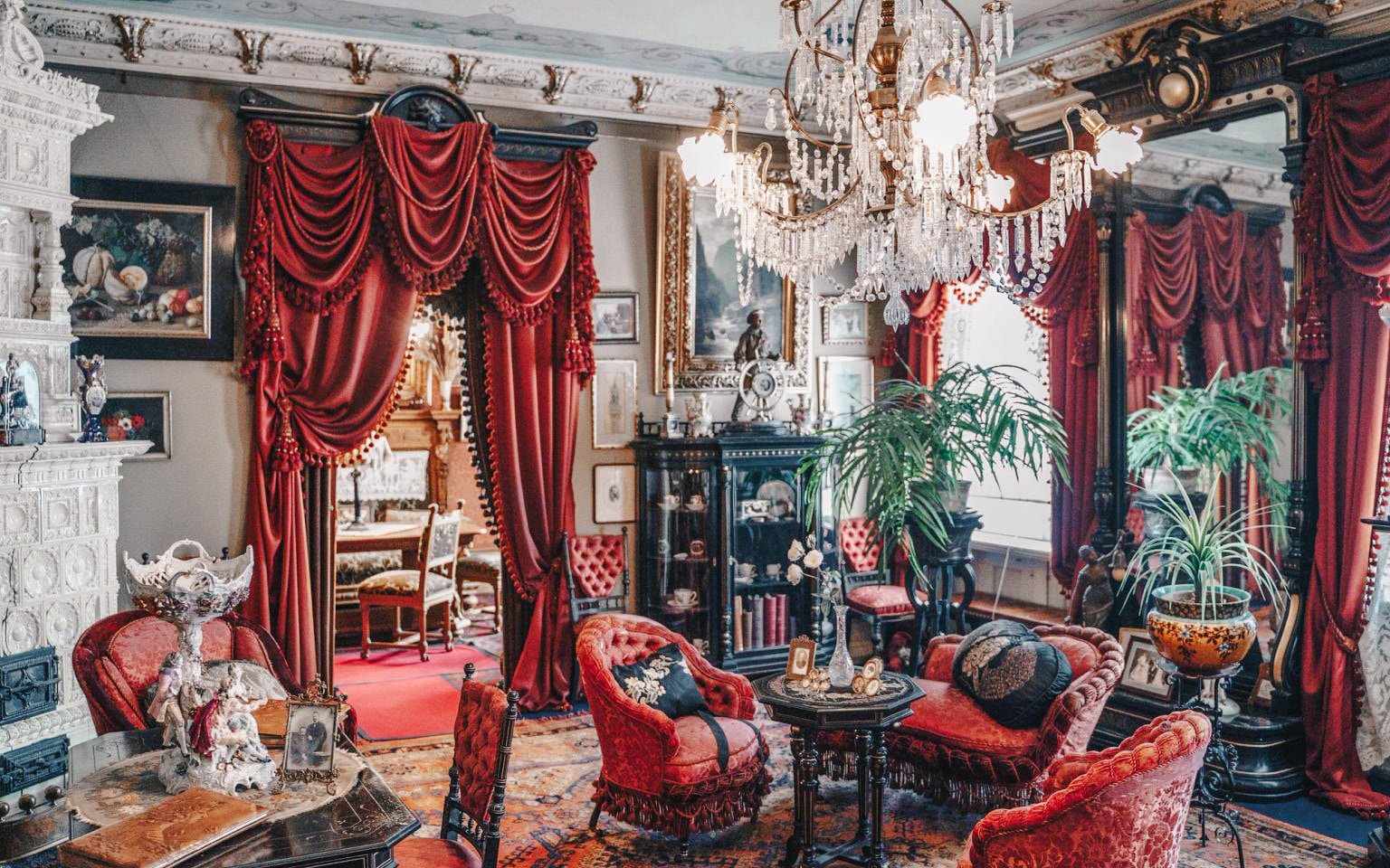 Victorian era room with ornate furniture and red drapes at The National Museum of Denmark.