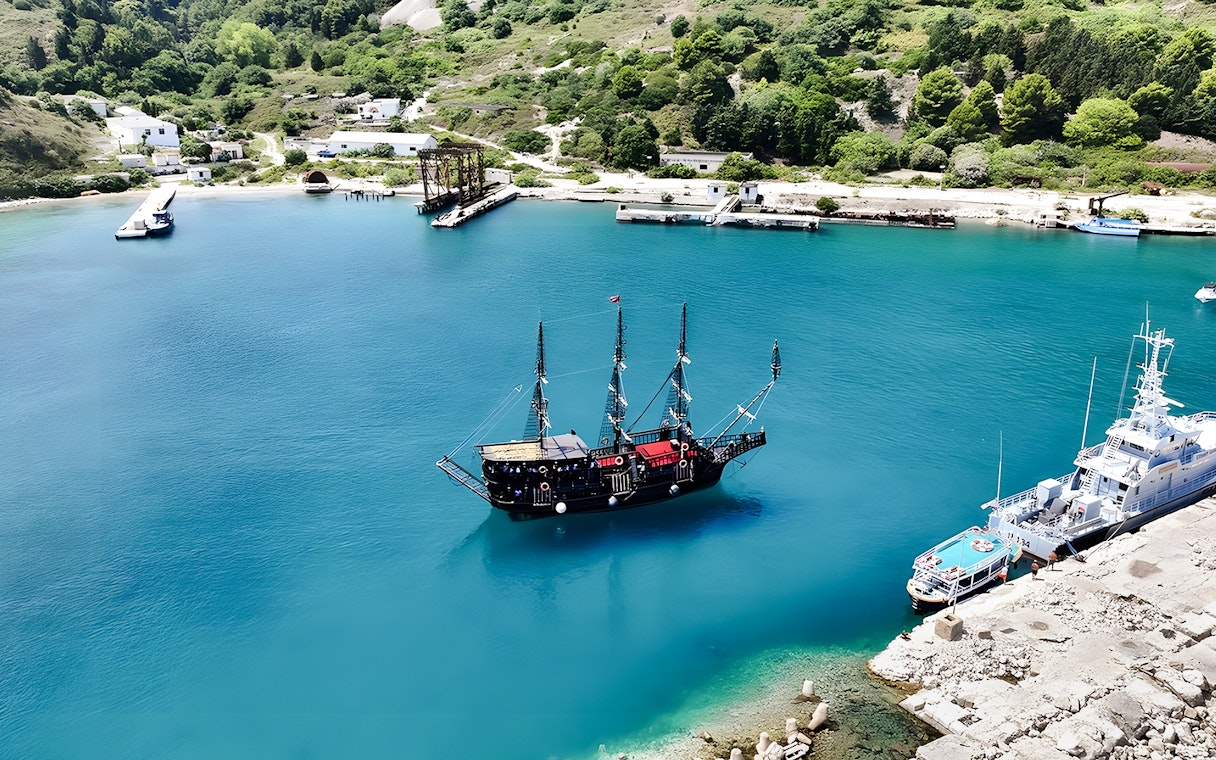 Pirate ship in Vlora's turquoise waters, part of the Ionian Odyssey tour, Albania.