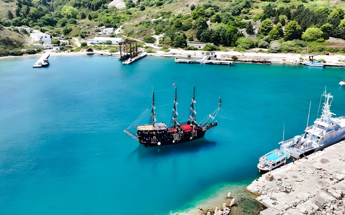 Pirate ship in Vlora's turquoise waters, part of the Ionian Odyssey tour, Albania.