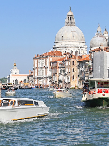 ACTV water bus navigating Grand Canal with Santa Maria della Salute in Venice.