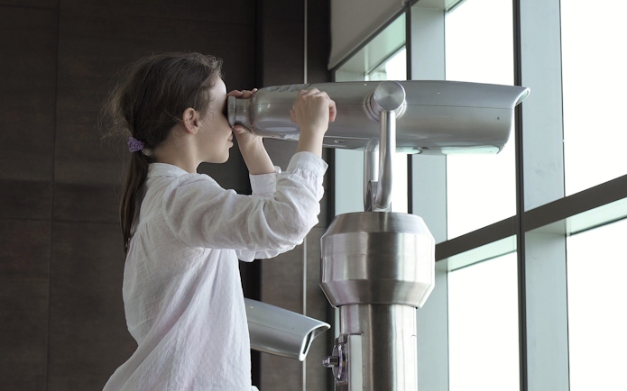 Person using a telescope at The View At The Palm, Dubai.