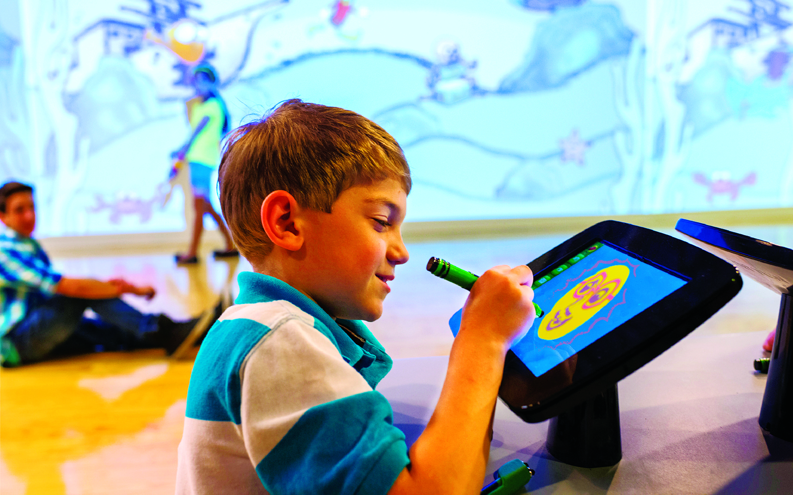 Young boy drawing on a digital screen at Crayola Experience, Mall of America.