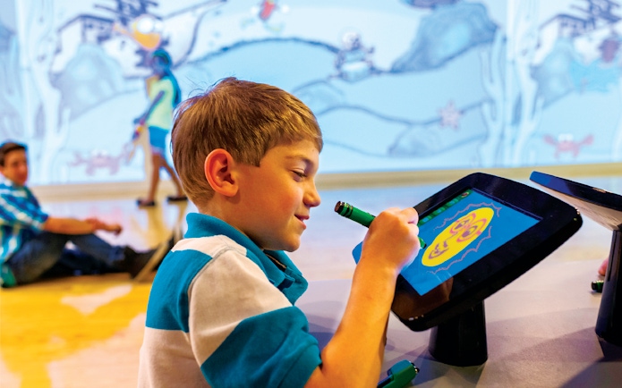 Young boy drawing on a digital screen at Crayola Experience, Mall of America.