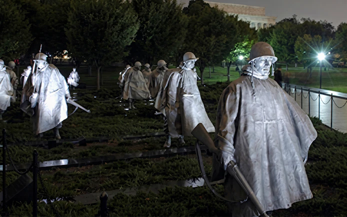 Korean War Veterans Memorial statues illuminated at night, Washington DC.