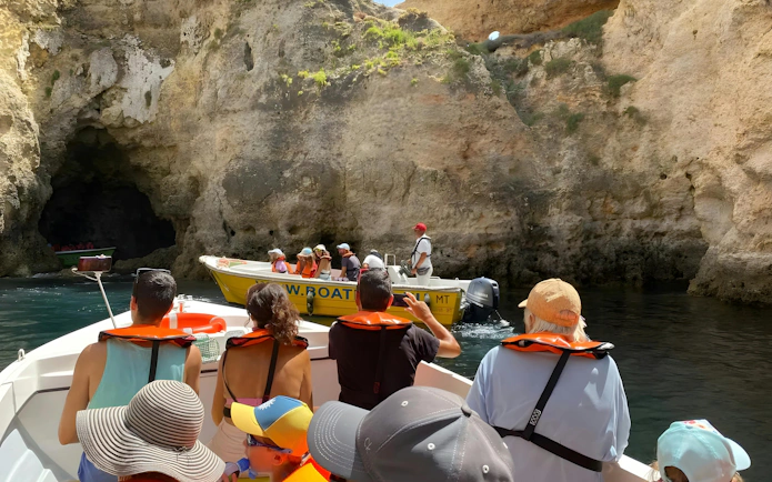 Tourists on a boat exploring caves during Ponta da Piedade private cruise in Portugal.