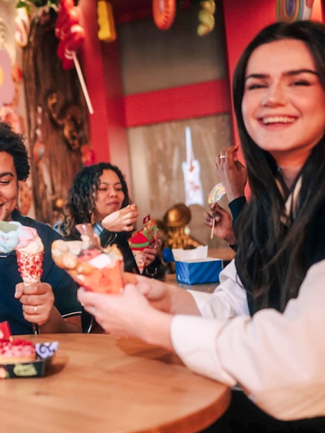 Visitors enjoying colorful desserts at Hansel and Gretel restaurant in Paradox Museum Paris.