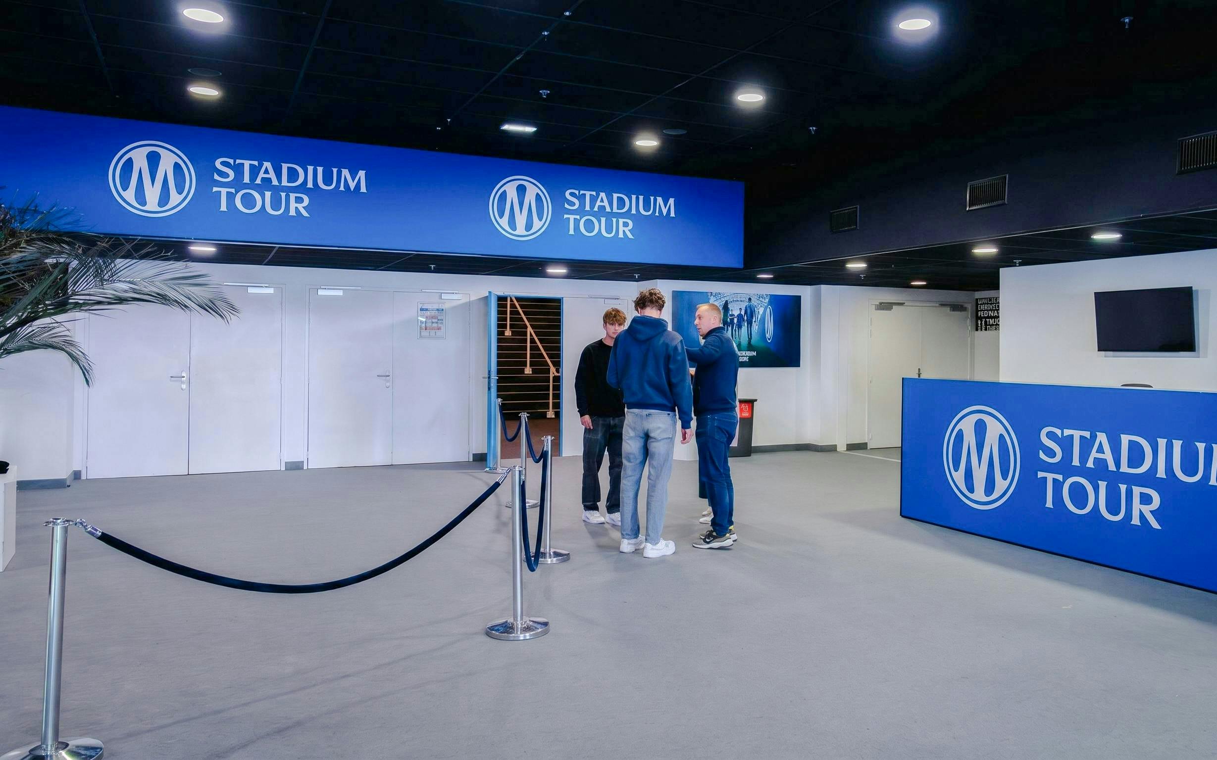 OM Stadium Tour entrance with visitors and signage.