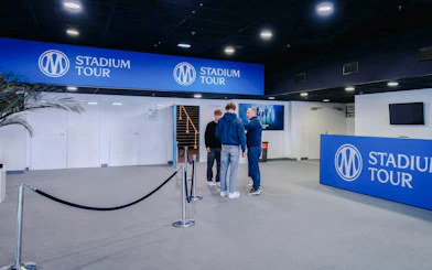 OM Stadium Tour entrance with visitors and signage.
