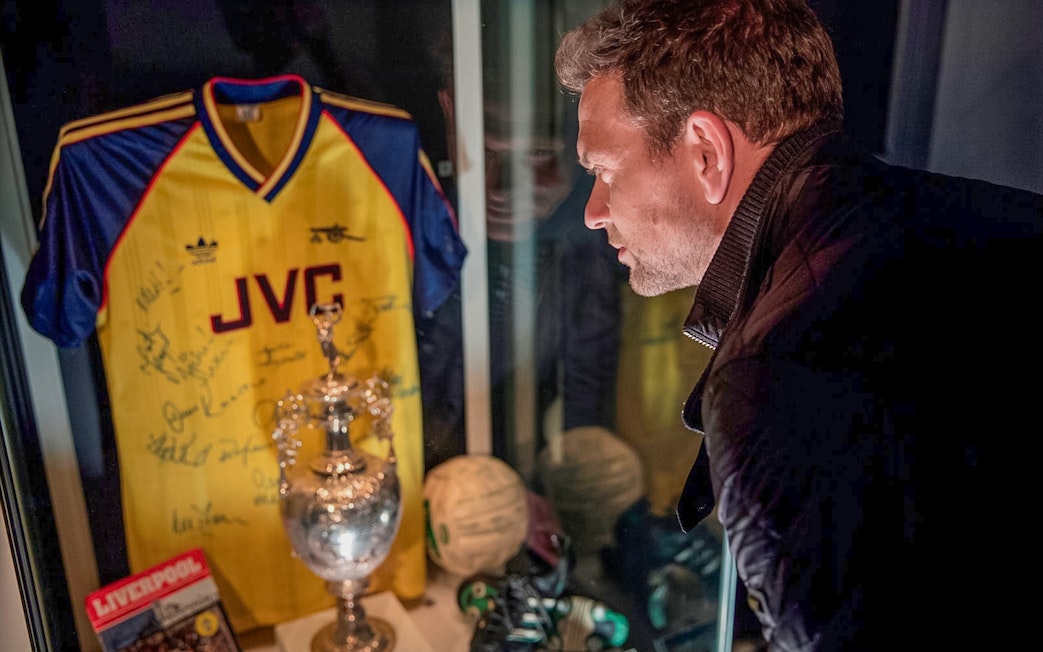 Tourist examining Arsenal memorabilia at Emirates Stadium in London.