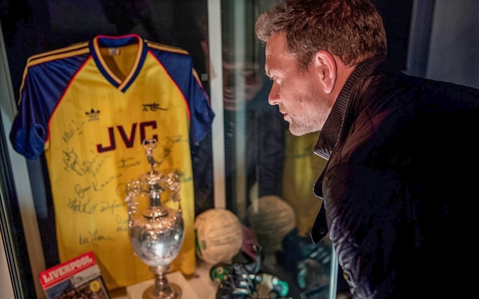 Tourist examining Arsenal memorabilia at Emirates Stadium in London.