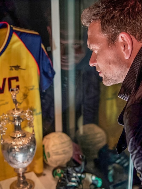Tourist examining Arsenal memorabilia at Emirates Stadium in London.