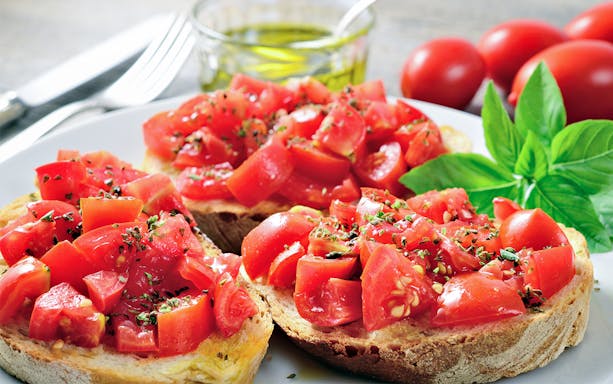 Tomato bruschetta with basil served on a plate, part of the Elphi Plaza und HafenCity tour.