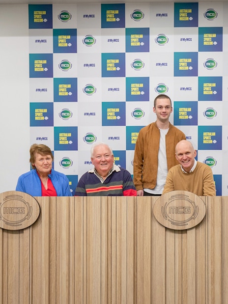 Group at Melbourne Cricket Ground press conference table.