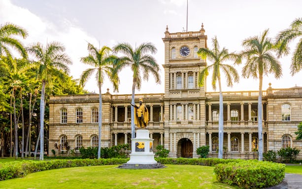 Statue of King Kamehameha with palm trees in front of Aliʻiolani Hale, Honolulu.
