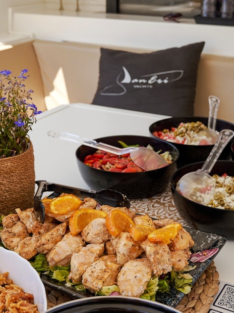 Grilled chicken and salads on a luxury catamaran cruise near Dia Island, Crete.