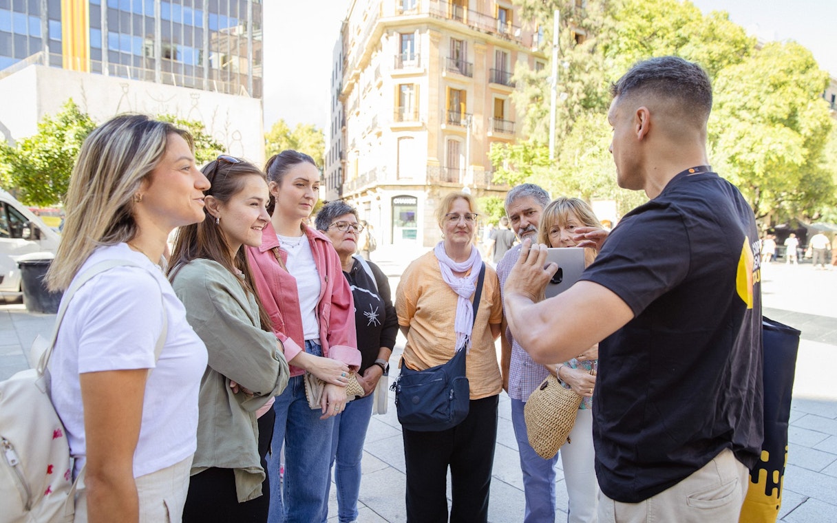 Tourists listening to a guide during a walking tour in Barcelona.