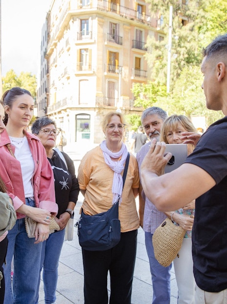 Tourists listening to a guide during a walking tour in Barcelona.