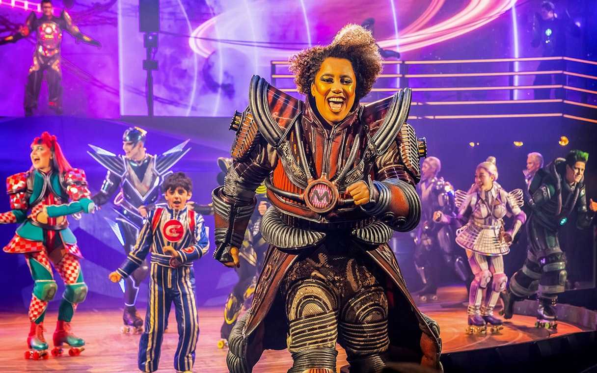 Performers in futuristic costumes on stage during Starlight Express show.