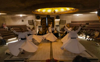 Whirling Dervishes performing Sema ceremony in a cave setting, Cappadocia.