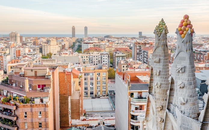 View of Barcelona from the Sagrada Familia's Nativity facade tower, showing cityscape and sea.
