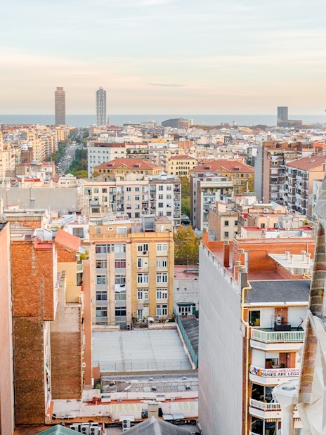 View of Barcelona from the Sagrada Familia's Nativity facade tower, showing cityscape and sea.