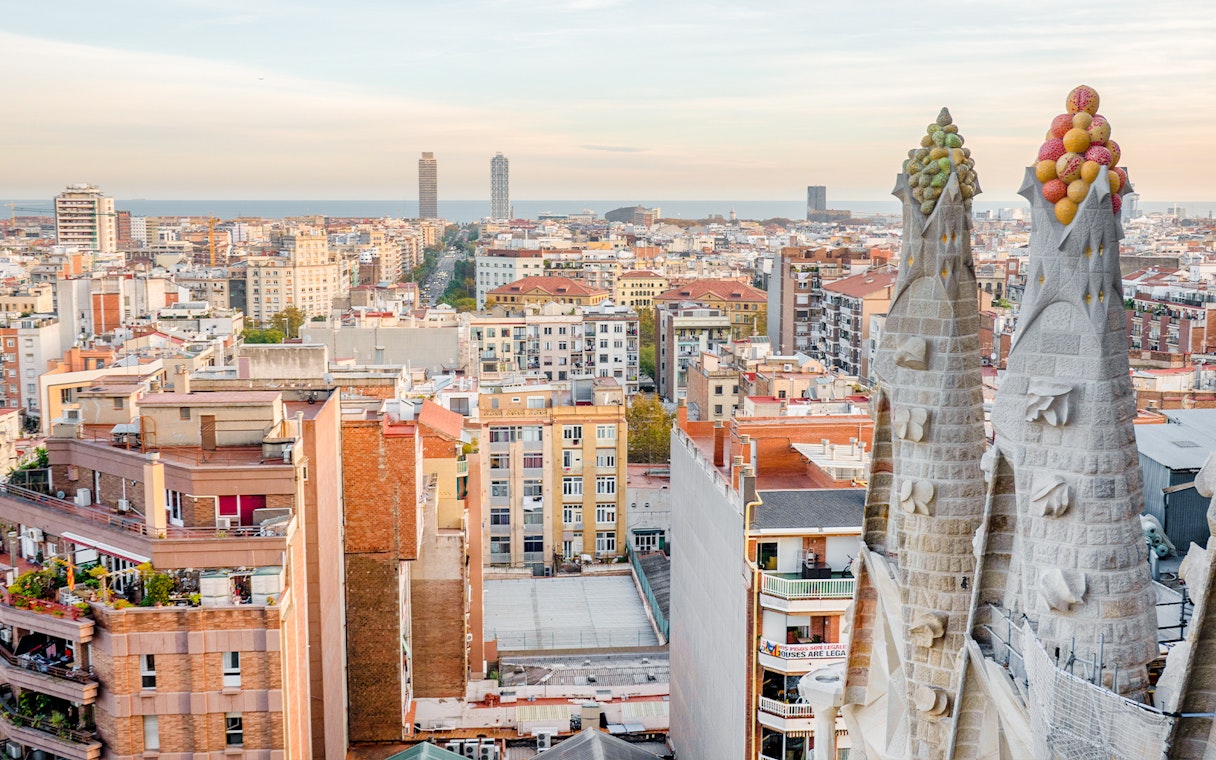 View of Barcelona from the Sagrada Familia's Nativity facade tower, showing cityscape and sea.