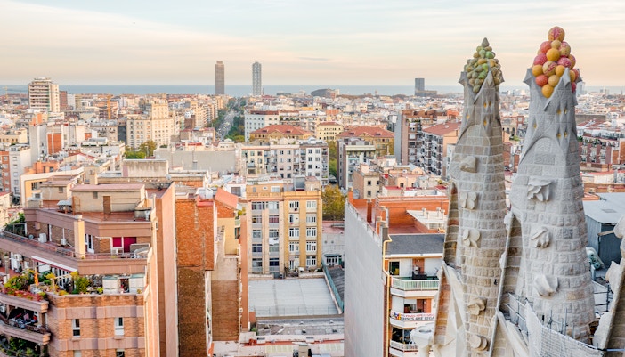 View of Barcelona from the Sagrada Familia's Nativity facade tower, showing cityscape and sea.