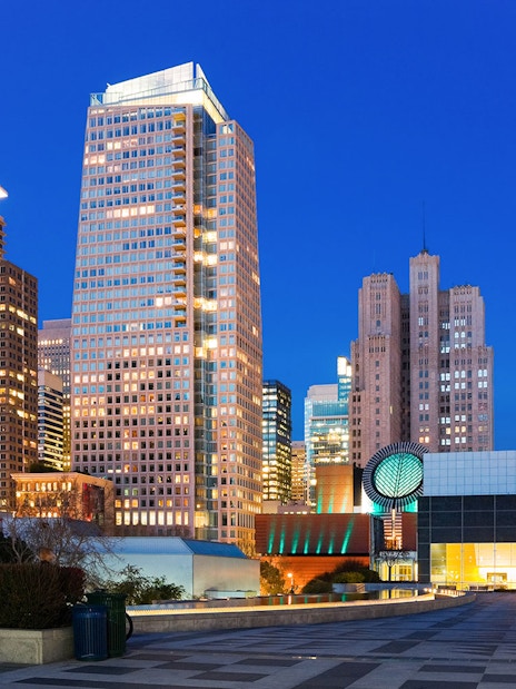 San Francisco Museum of Modern Art with city skyline at dusk.