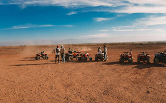 Quad bikes and riders in the desert during a Marrakech sunrise tour.