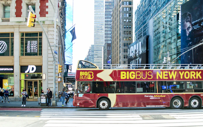 Hop-on hop-off bus in New York City near Empire State Building.