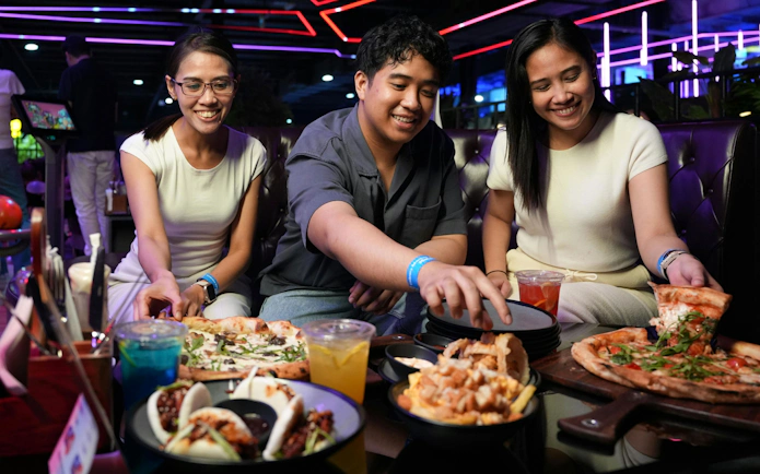 Group enjoying pizza and tacos at Loco Bear, Dubai.
