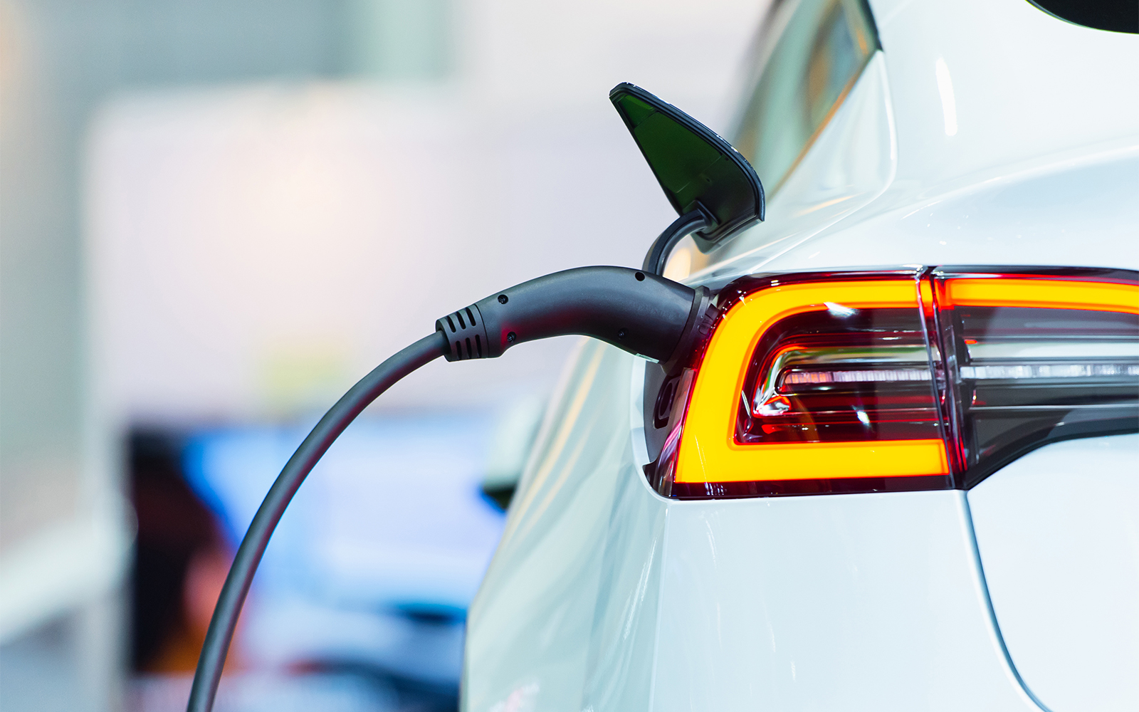 Electric car plugged into charging station.