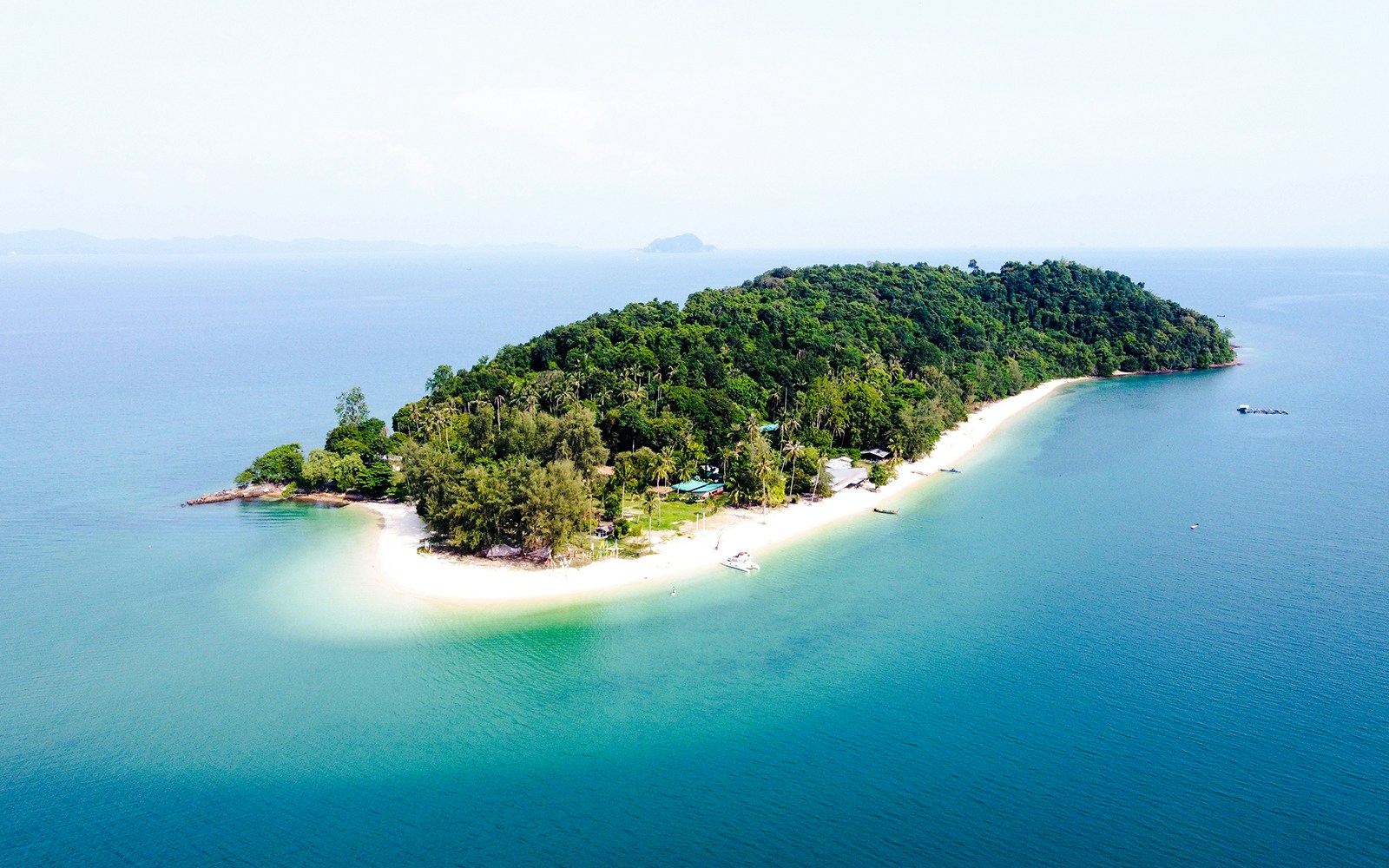 Aerial view of Naka Noi Island's lush greenery and sandy beaches in Phuket, Thailand.
