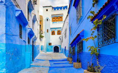 Narrow blue alley with traditional buildings in Chefchaouen, Morocco.