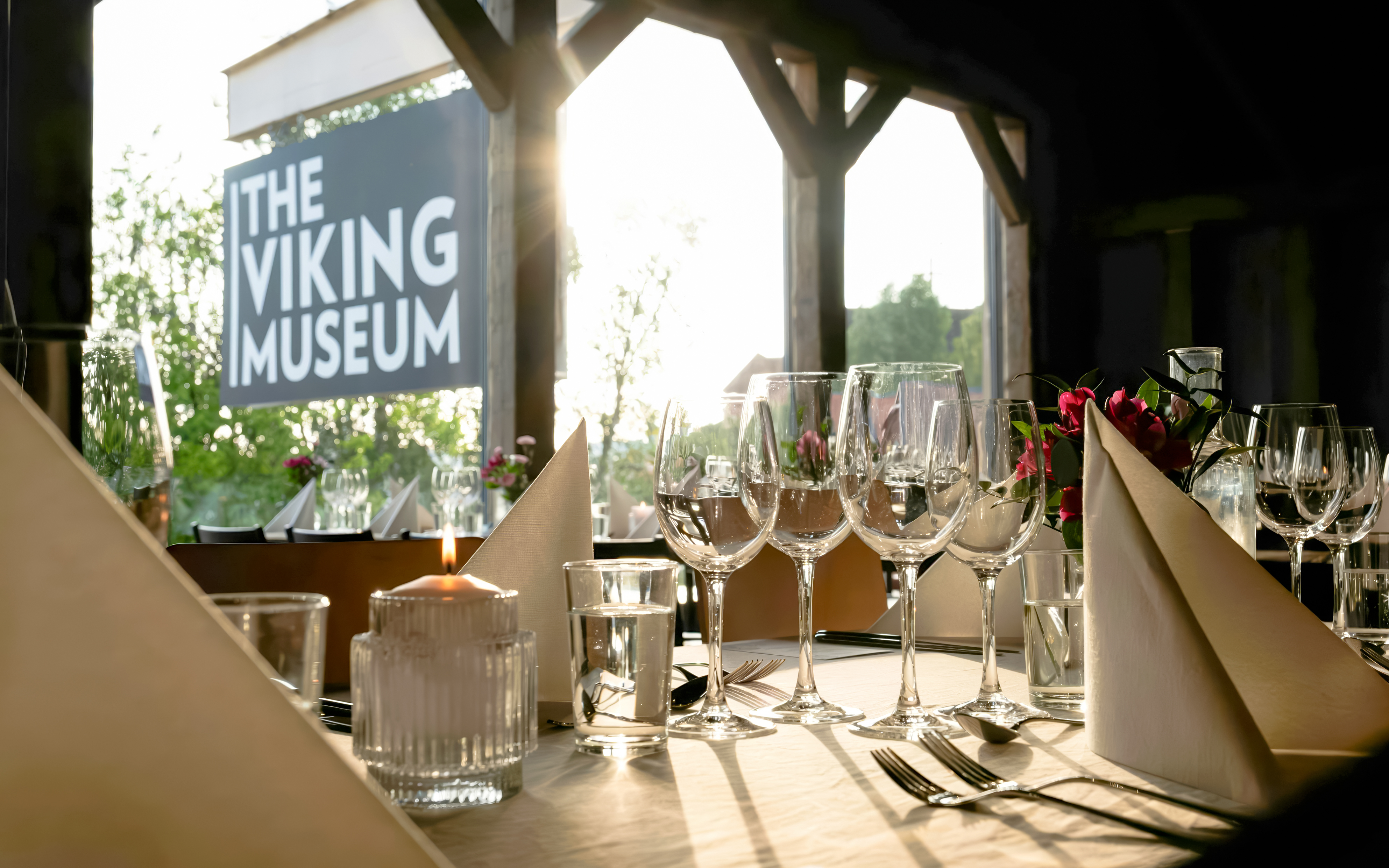 Dining setup at the Viking Museum in Stockholm, Sweden with wine glasses and candlelight.