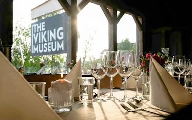 Dining setup at the Viking Museum in Stockholm, Sweden with wine glasses and candlelight.