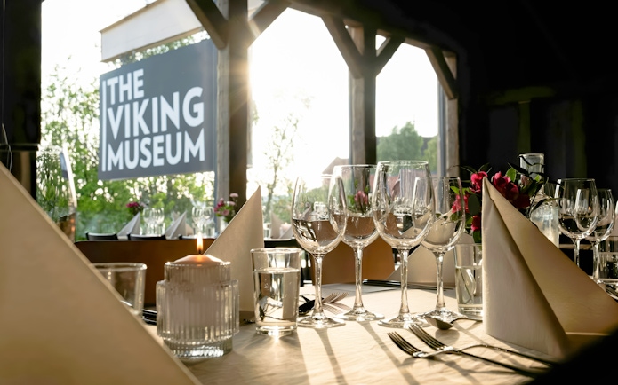 Dining setup at the Viking Museum in Stockholm, Sweden with wine glasses and candlelight.