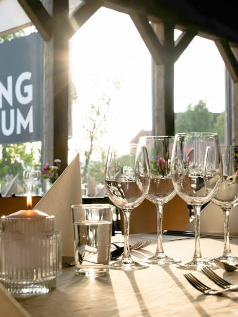 Dining setup at the Viking Museum in Stockholm, Sweden with wine glasses and candlelight.