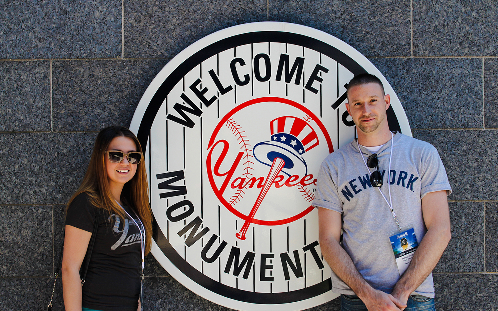 Visitors at Yankee Stadium Monument Park sign.