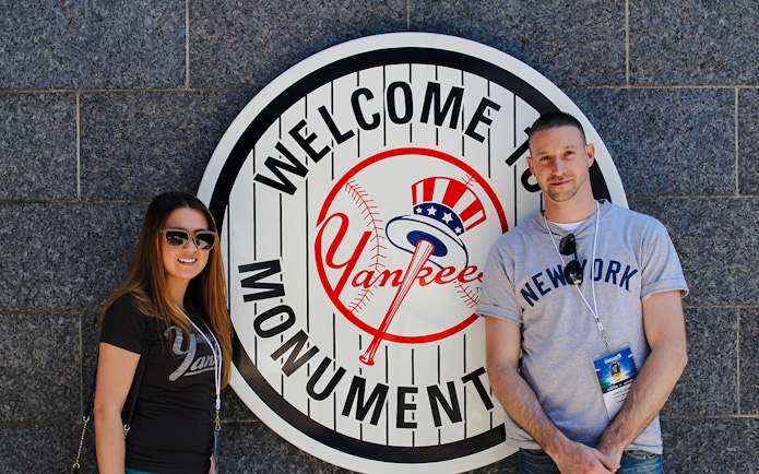 Visitors at Yankee Stadium Monument Park sign.