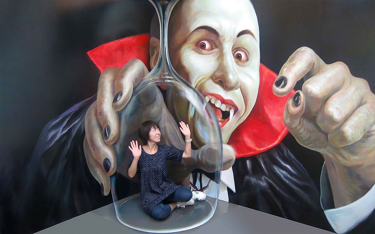 Person interacting with vampire illusion at Tokyo Trick Art Labyrinth Museum.