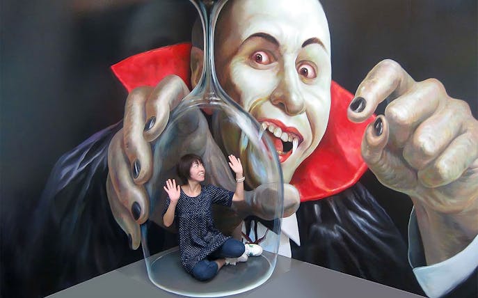 Person interacting with vampire illusion at Tokyo Trick Art Labyrinth Museum.
